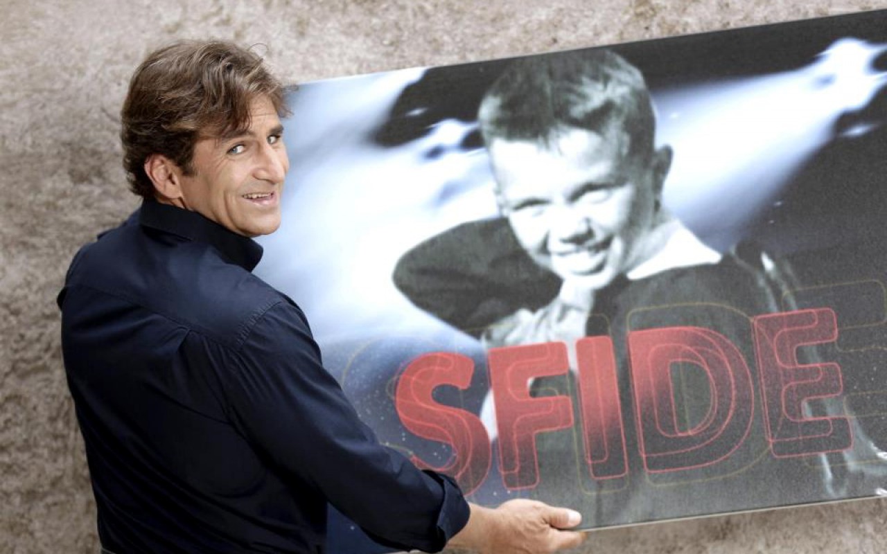 Alex Zanardi che guarda verso il fotografo e di sfondo lui bambino